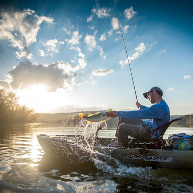 Lifestyle image of a man catching a fish in a Titan 10.5 Fishing Kayak