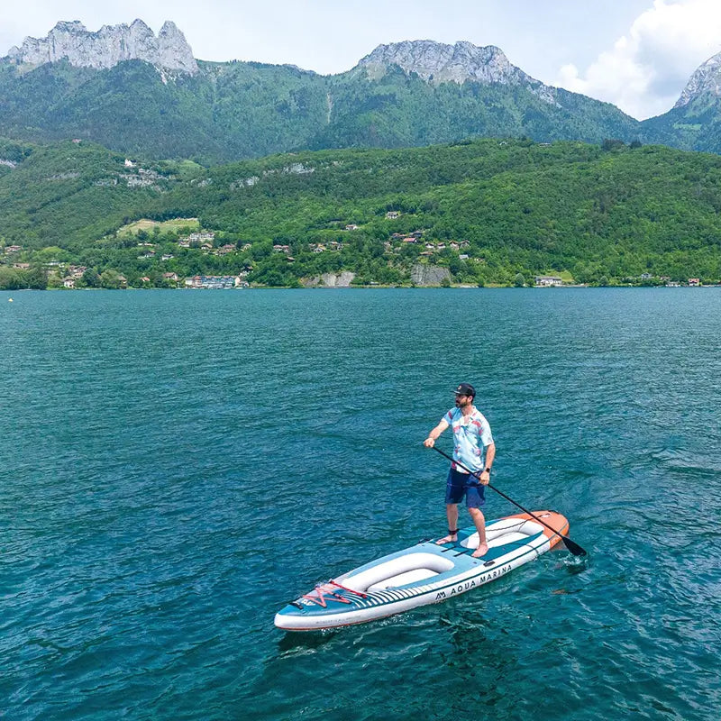 Drone shot of a man paddling the cascade from Aqua Marina in a mountainous location