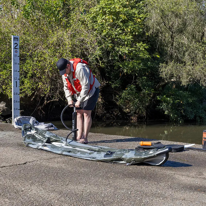 A photo of a man inflating the Quest Angler Inflatable Fishing Kayak